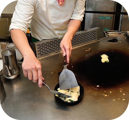 師傅正在使用鐵板專注地製作料理